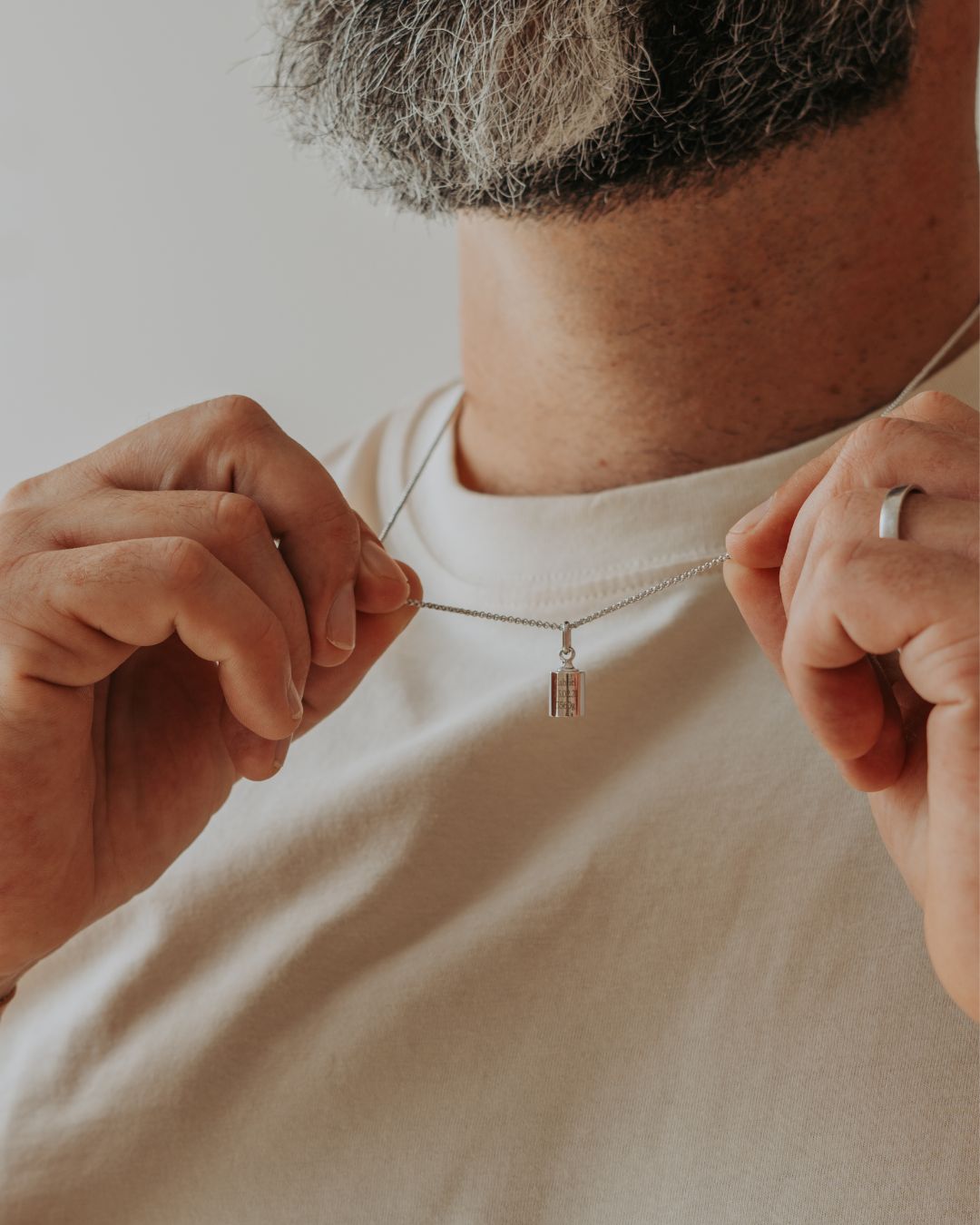 Homme tenant son collier Mon Petit Poids entre ses mains