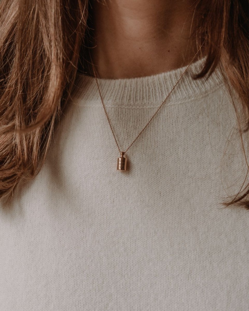 Collier Mon Petit Poids plaqué or rose porté par une femme sur un pull en maille fine blanc