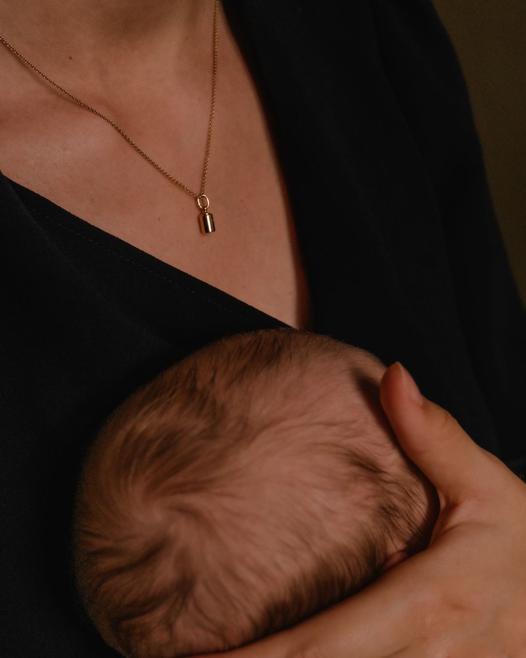 Maman portant un bijou Émotion en or jaune 18 carats avec son bébé dans les bras