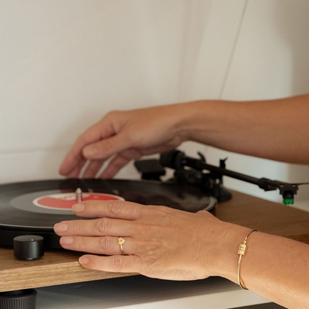 Bague Simone perlé, porté par une femme remettant un vinyle 
