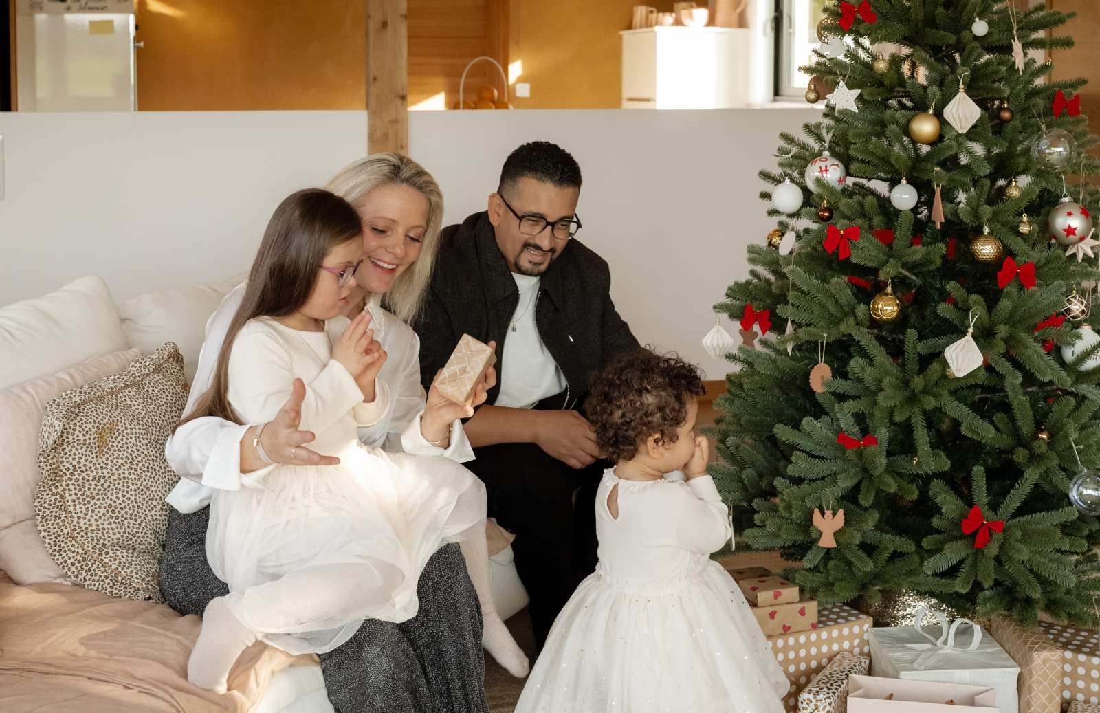 Moment en famille à l'ouverture des cadeaux sous le sapin de Noël