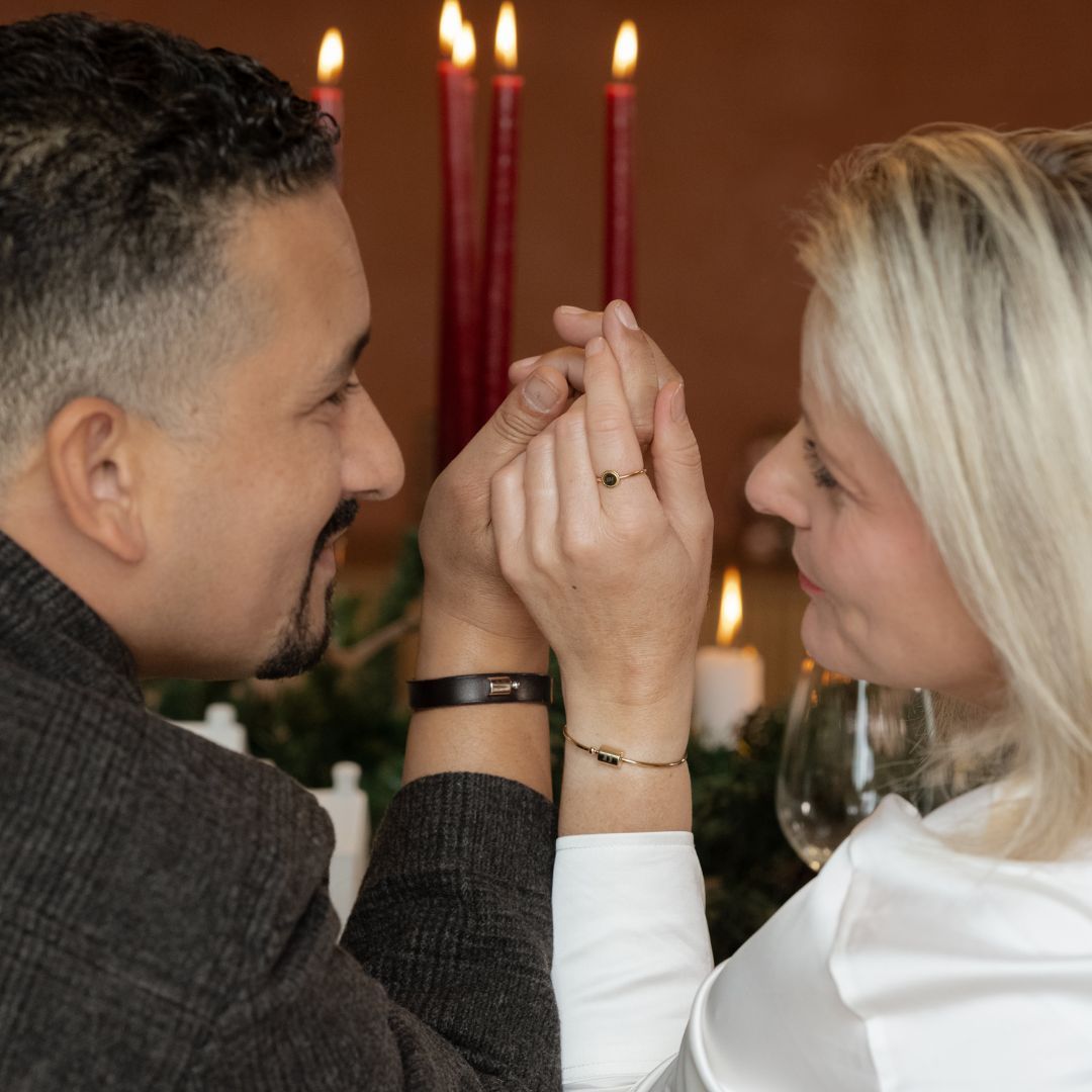 Couple se tenant la main et se regardant dans les yeux, portant tous les deux des bracelets. Elle porte un jonc Mon Petit Poids et il porte un bracelet cuir Mon Petit Poids