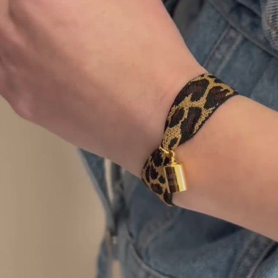 Coffret bracelet Mon Petit Poids léopard porté au poignet avec un pendentif gravé