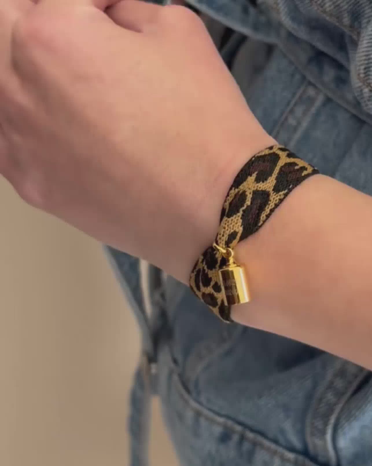 Coffret bracelet Mon Petit Poids léopard porté au poignet avec un pendentif gravé