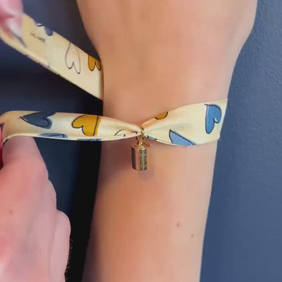 Vidéo du bracelet personnalisable Les Mots Bleus en plaqué or jaune avec ruban en soie – bijou personnalisé gravé pour femme.