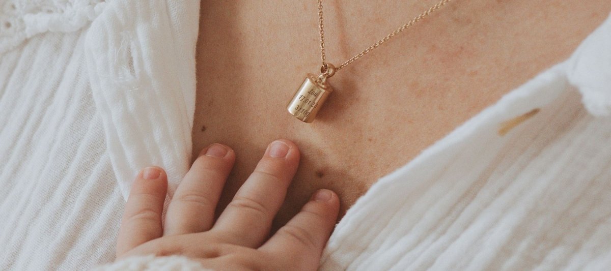 Collier Mon Petit Poids Plaqué or jaune porté par une maman avec la main de son bébé